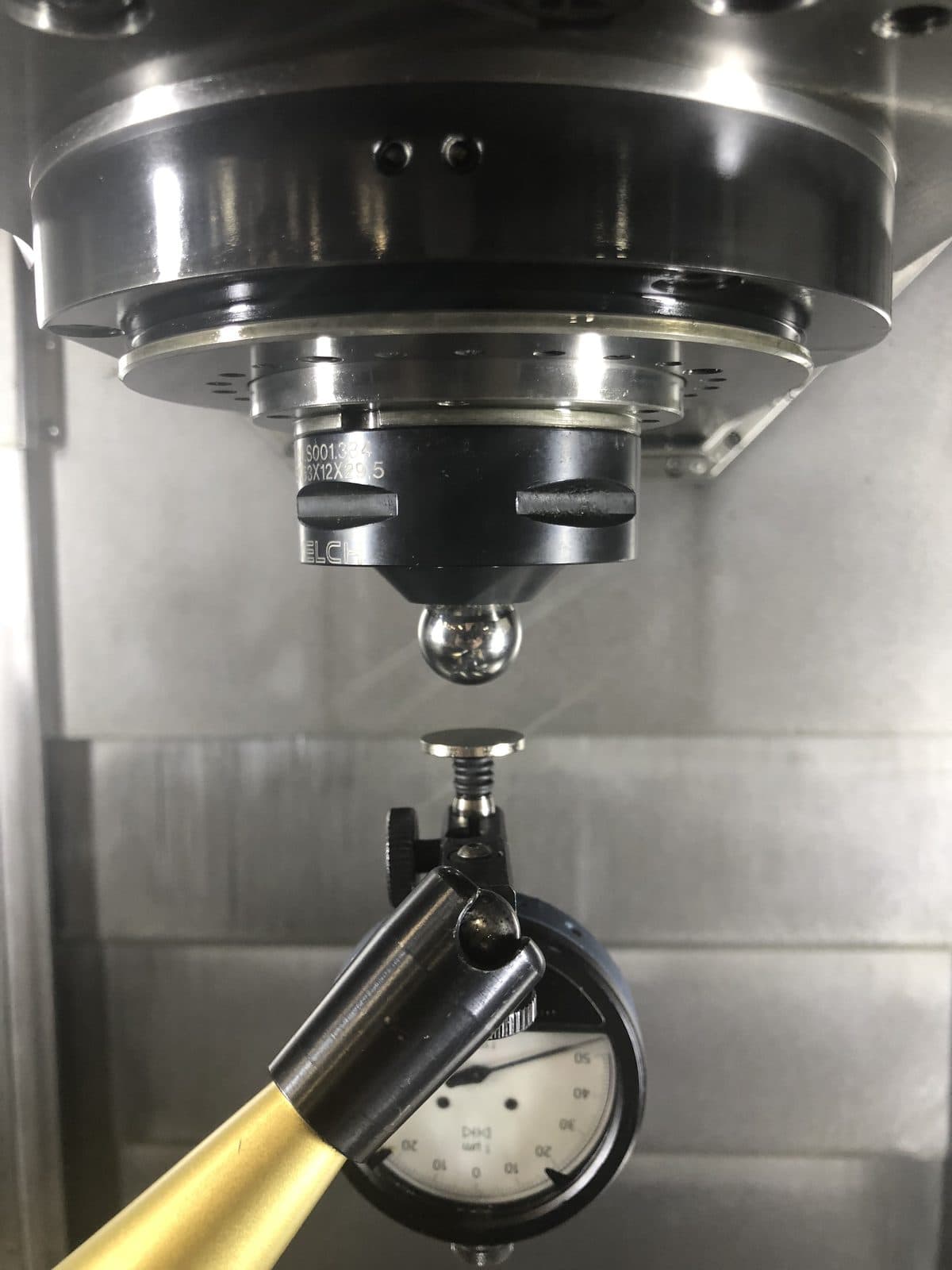 Spindle probe verifying position against a precision dial indicator during DMG MORI service.